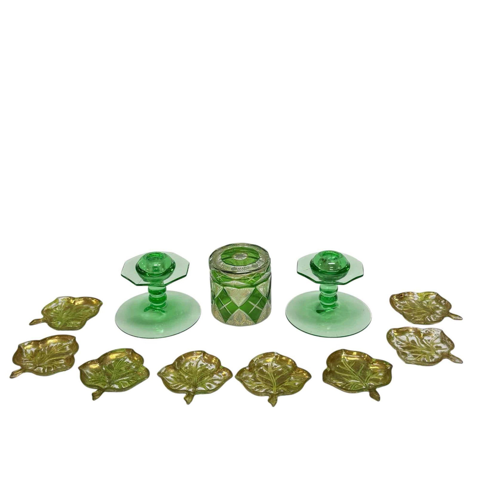 Green Glass Bohemian Art Deco Candlestick and Leaf Nut/Candy Dishes: Group includes; Bohemian green cut to clear with etched gold floral lidded jar 3.5" tall, pair of Art Deco depression candlesticks 3.75" tall and 8 green with gold leaf pressed glass leaf form candy/n