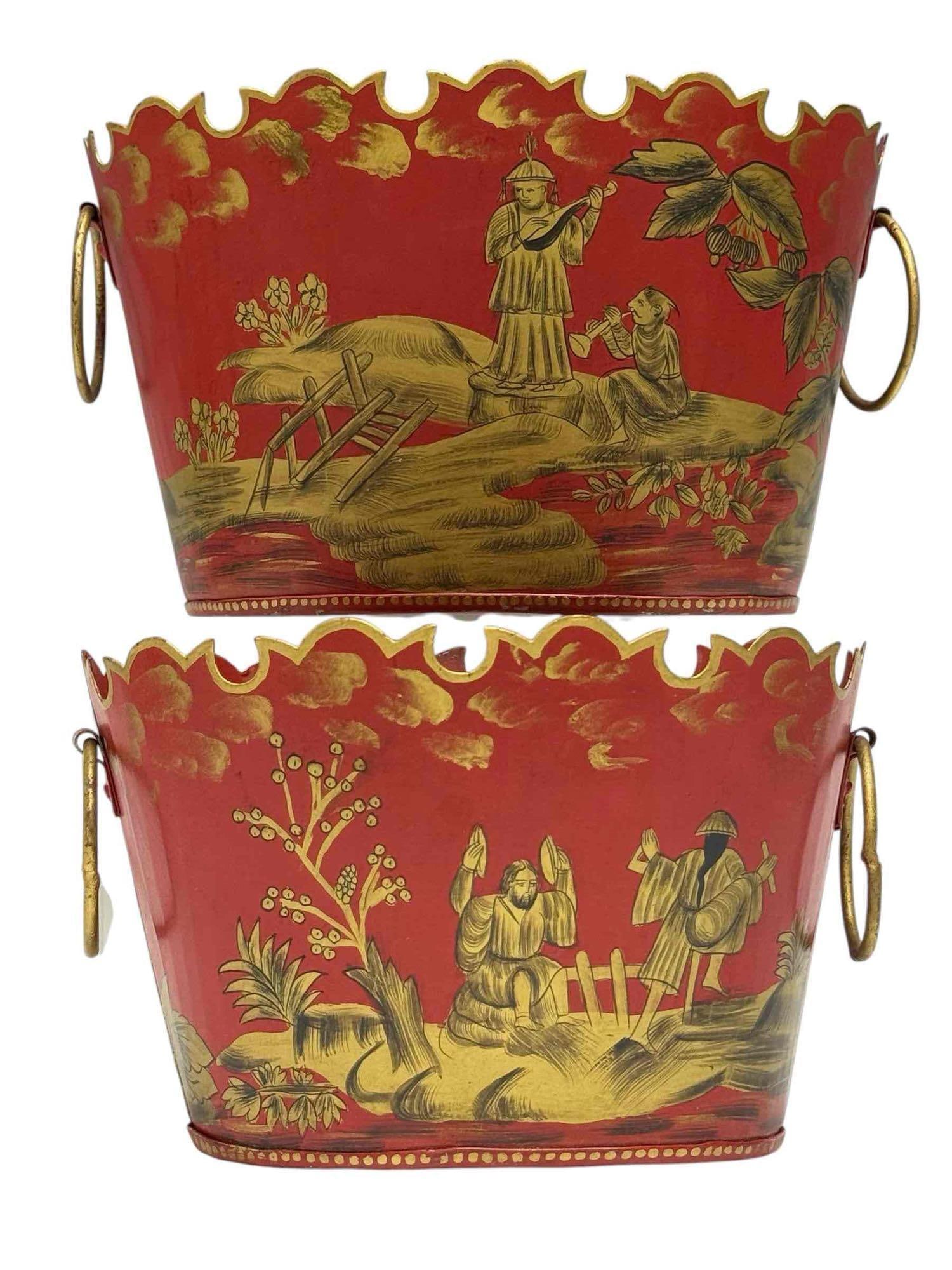 Red Gold Chinoiserie Metal Tole Cachepots with Scalloped Rims (2): Two nesting red and gold Chinoiserie hand painted metal tole cachepots. Having scalloped rims, ring handles and depicting Asian musical figures. Measuring approx. 6.5" tall 10.25" wide for the largest