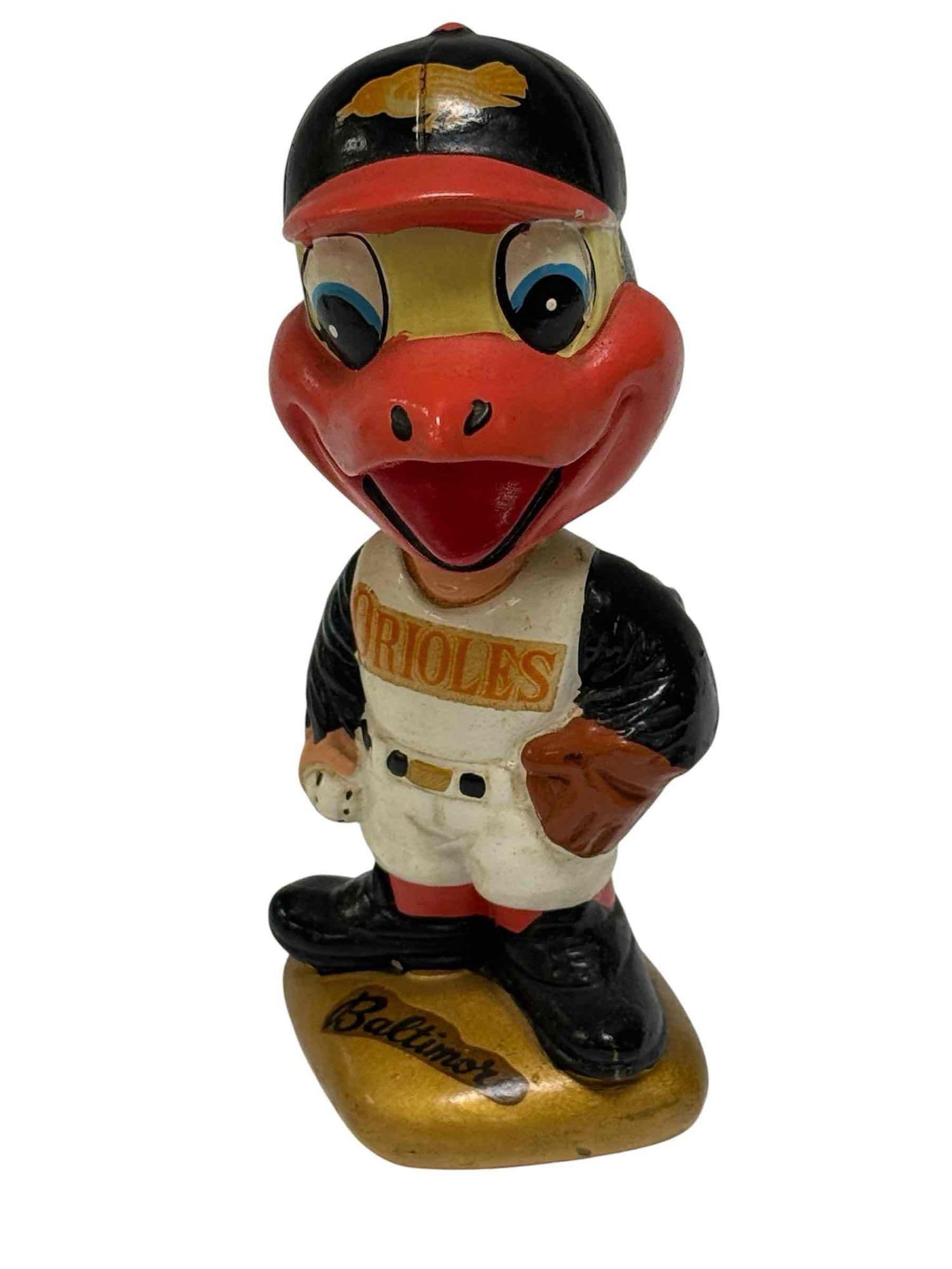 1960's Baltimore Orioles Bobblehead GOLD BASE Version: Early 1960's nodder with a gold base shaped like a baseball base. There are white versions that are even earlier. This features the colorful Oriole mascot head. Great classic item! Age appropriate sig