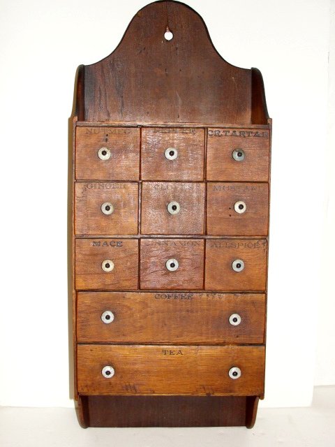 Early 12 Drawer Spice Cabinet Late 19th. C.: Country wall hanging spice cabinet havening stenciled impressed spice names on each drawer, white porcelain knobs and shaped top with hole to hang. Condition overall very good, light color wear and sm