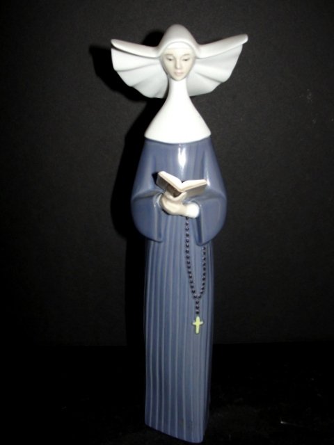 Lladro Figurine #5500 Prayerful Moments: Modeled by Jose Puche.Â Prayerful Moments vintage Daisa 1987; porcelain blue nun with book and rosary beads handmade in Spain; 10-1/2". Condition mint.