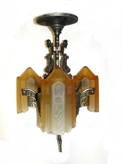 Art Deco Slip Shade Three Light Chandelier: Having true deco style metal frame with 3 embossed Carmel color slip shade. Condition very good, one very small chip on one shade. Frame 22'' tall 11 1/2'' diam. Shades 8 1/2' long 'x 4 3/4'' tall.