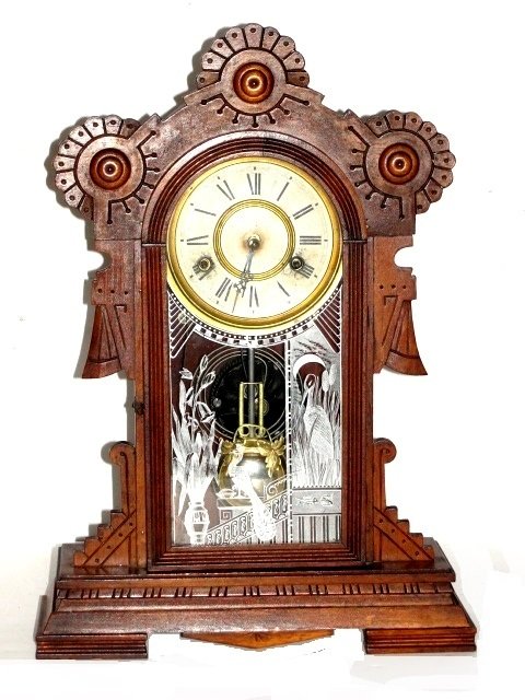 Wm. Gilbert Victorian Mantle Clock '' EDINA'': Carved walnut case with alarm bell. Condition very good old original finish in working order. H 18'' W. 13'' D. 4 1/2''