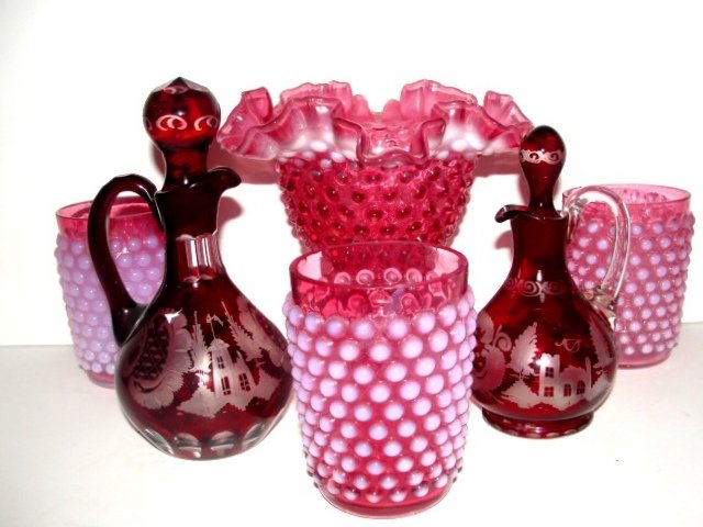 Fenton Cranberry And Ruby Glass Collection: Including cranberry opalescent hobnail ruffle top vase 4'' x 6 1/2''., 3 Fenton cranberry pinkish opalescent water glasses 4'' tall., Pair of Bohemian Ruby cut to clear cruet with stopper, having cast