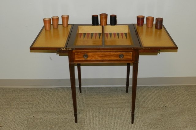1940's Mahogany and Satin Wood Gaming Table: Flip-Top Hepplewhite style gaming table that includes a Backgammon game in the inset, along with the gaming cups. Measures 29" tall, with a square (unopened) 21" top.