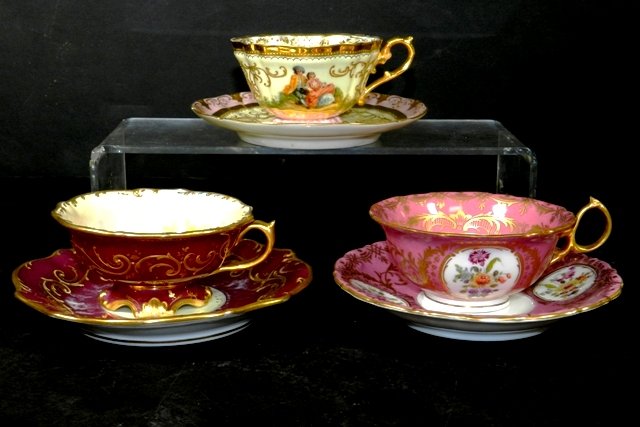 Three Continental Cups and Saucers- Royal Vienna: Three continental porcelain cups and saucers including Royal Vienna, Dresden, and Royal Saxe. Age appropriate conditions including a small chip on the Dresden saucer. Saucers measure between 5.5"-6"w.