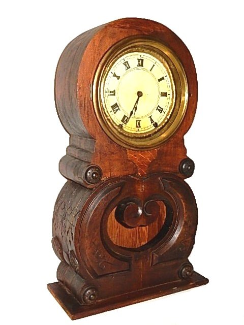 Oak Empire Figural Eight Mantle Clock: Having round top and pen door bottom. Clock has a figure 8 style with incised carving on bottom half. Condition back has been replaced, has been stripped and restained, top shows wood sections not sur