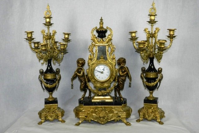French Garniture Reproduction Set: Late 20th c. Italian made French Garniture reproduction set of candlesticks and battery operated clock. Marble body with brass ormolu mounts, figures and candle arms. Clock 24.5", candlesticks 27".