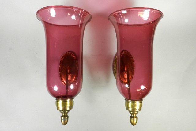 Pr. Cranberry Glass Wall Sconces With Brass Fittings: Cranberry glass wall sconces, turned arm brass fittings and wall plate, turn of the century. Shades H 13". Overall good condition, no cracks in the glass.