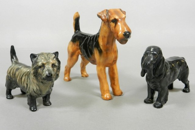 Three Royal Doulton Dogs: Three porcelain Royal Doulton dog figurines including: Welsh Terrier, Australian Terrier, and black Bloodhound. Overall good condition, no chips or cracks.