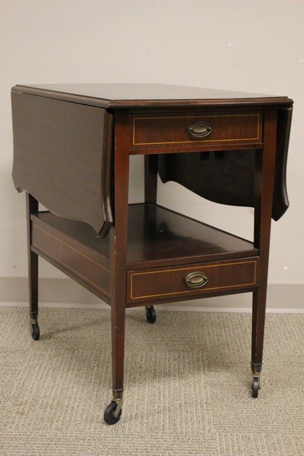 1940's Mahogany Service Tea Cat: 1940's Mahogany Service Tea Cat having fine details in the string inlay throughout, shapely corners on drop side and brass Duncan phyfe style hardware. One upper storage drawer. Measures approx. 29"ta