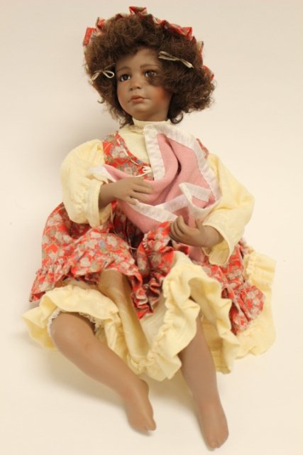Dulcie by Yolando Bello: African women carrying porcelain dog in blanket. Red flowered dress with matching hat. Porcelain standing approx. 16 1/2".