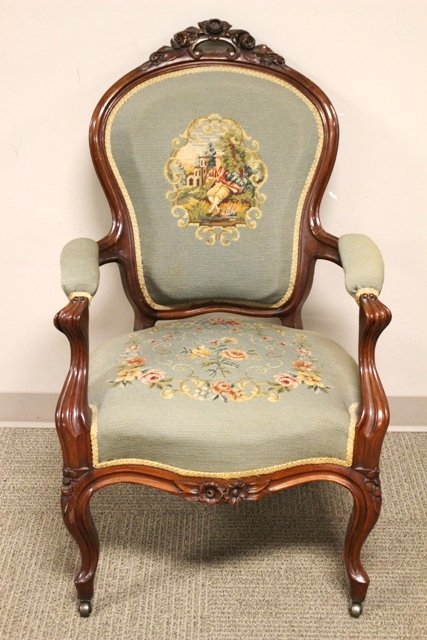 Carved Victorian Needlepoint Arm Chair: ca. 1870 Carved walnut frame with rosewood carved back, original needlepoint upholstery and brass castors. H. 40" W. 25" D. 22".