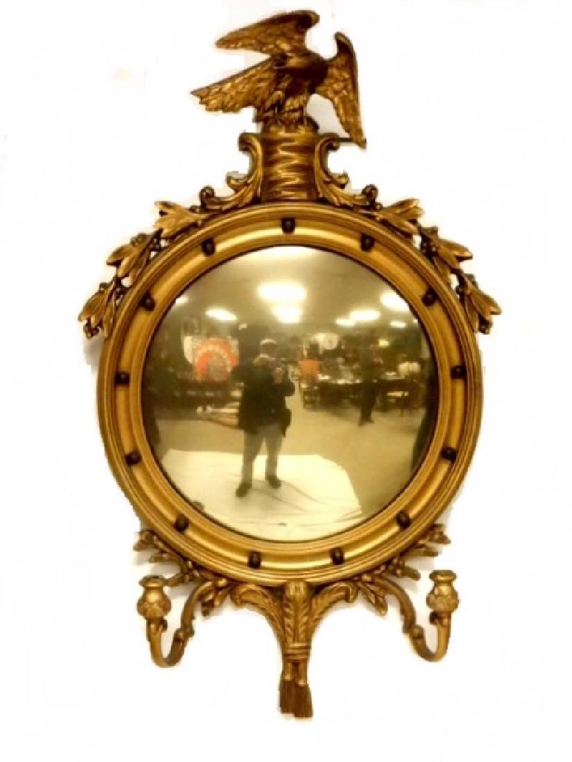 Bulls Eye Convex Mirror With Candle Holders: Regency style 1930's bulls eye mirror with double candle holder arms and eagle crest. Mirror has a gold tint glass. Condition overall good, normal wear for age use. H. 40'' W. 22''