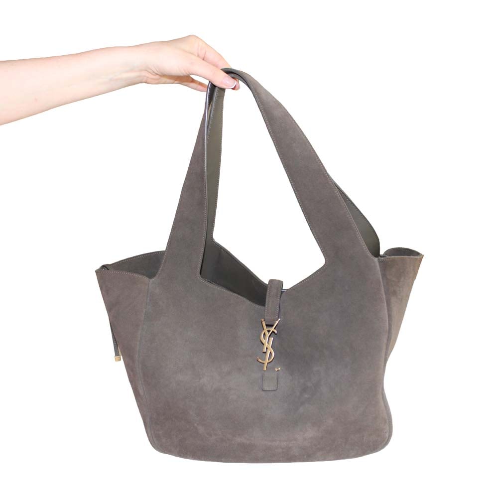 Saint Laurent Style Suede Tote Bag: Saint Laurent tote crafted in supple suede. Features an inner zip pocket and a leather tab closure engraved with the SL logo. The east-west silhouette offers generous space, with sides that can be col