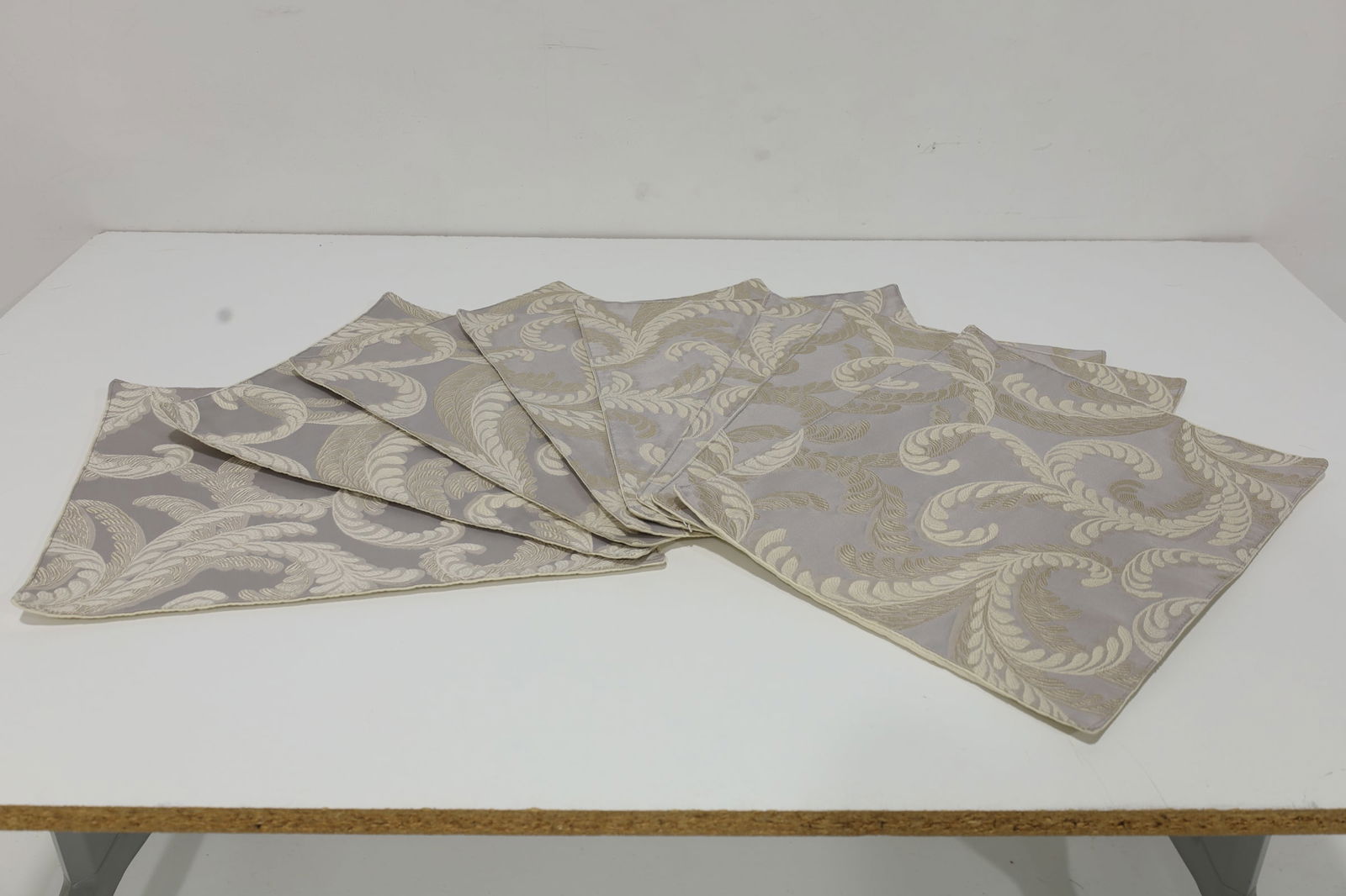 Set of Eight High-Quality Placemats: A beautiful set of formal dinner placemats in embroidered fabric with silver, off-whites. Gently used. See matching napkins in separate lot.
