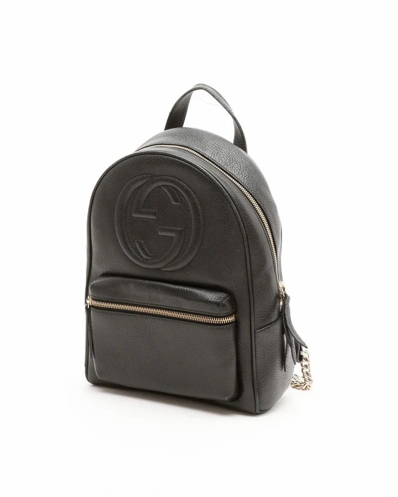 Gucci Black Leather Soho Handbag: Gucci Soho Backpack made from black pebbled leather with gold-tone hardware, featuring a zip-around closure, adjustable shoulder straps with chain-link detail, and beige canvas lining.