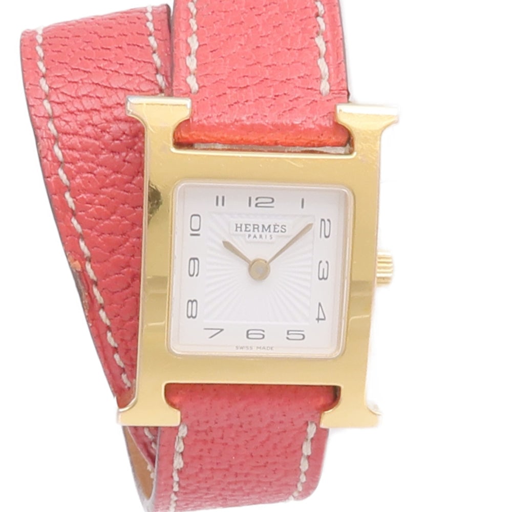 Hermes H Watch HH1.201 Quartz White: Quartz H Watch HH1.201 in stainless steel, gold plated finish and leather belt with white dial. Case 30x21mm, wrist 13-14.5cm, band 15mm. Includes storage box and guarantee.