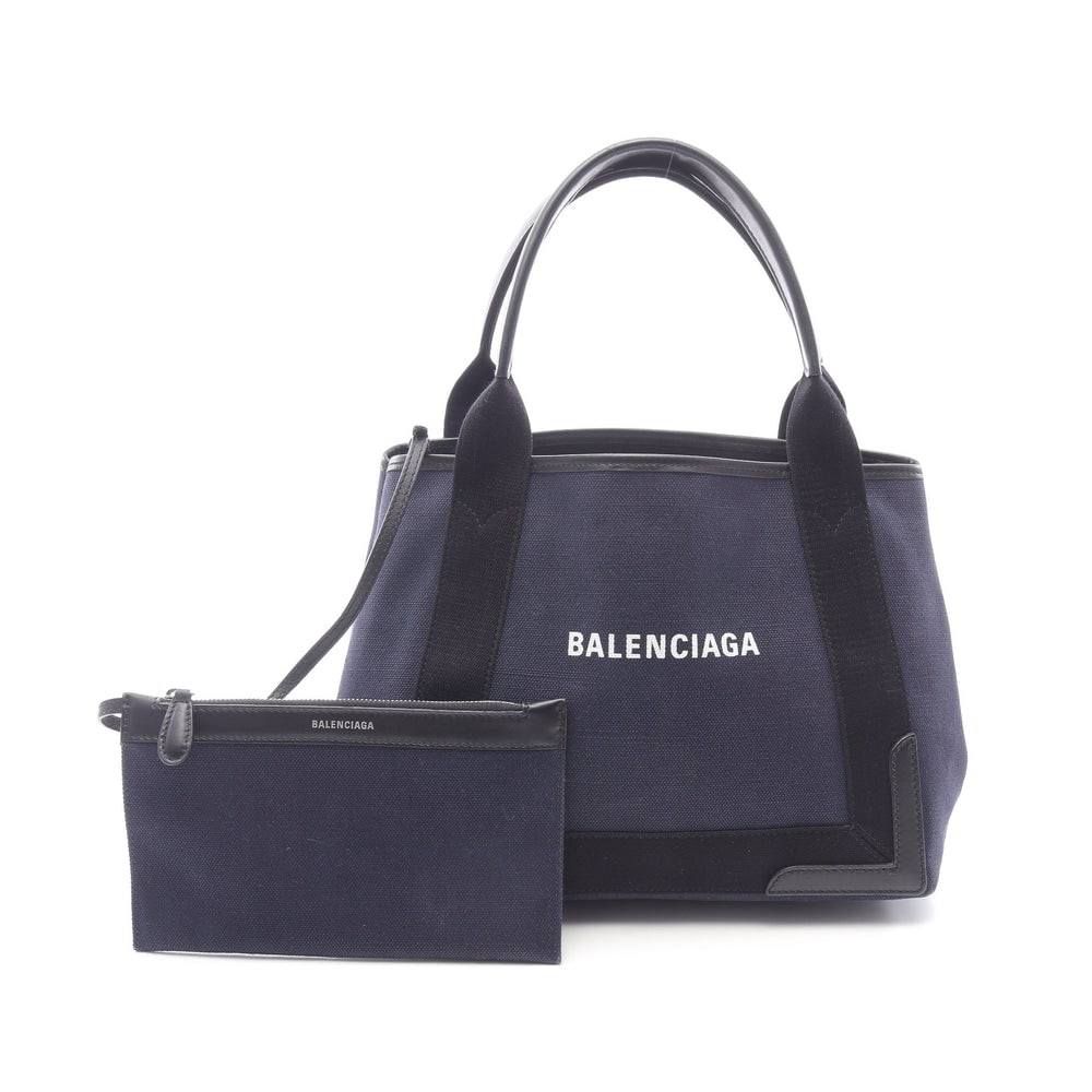 Balenciaga Navy Cabas S Tote Navy: Authentic and authenticated Balenciaga Navy Cabas S tote handbag in dark navy and black canvas leather. Model 339933. Approx. 24H x 32/30W x 17D cm with 45 cm handle. Includes pouch.