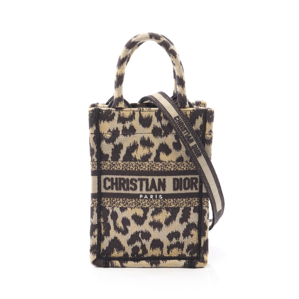 Dior Book Tote Mini Phone Leopard: Beige and black leopard canvas Dior Book Tote Mini Phone bag. Approx. 13 x 18 x 6 cm; handle 21 cm; strap 70-125 cm. Authentic and authenticated.