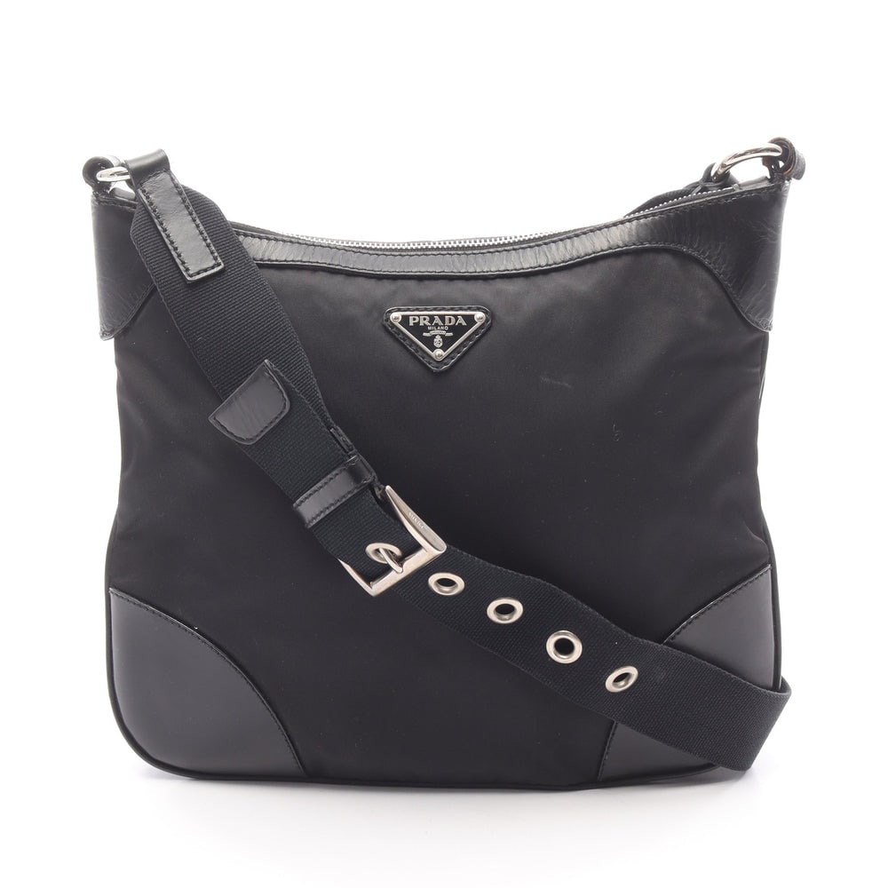 Prada Nylon Leather Shoulder Bag: Authentic and authenticated Prada shoulder bag in black nylon and leather. Approx. 25H x 29W x 7D cm with 110-112 cm strap. No accessories listed.