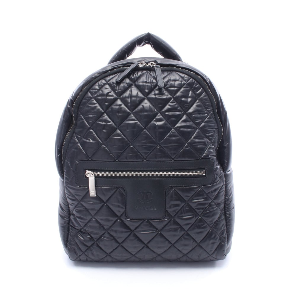 Chanel Coco Coon Backpack Black: Black nylon and leather backpack with silver hardware. Includes guarantee card and serial seal. 29 x 35 x 11 cm.