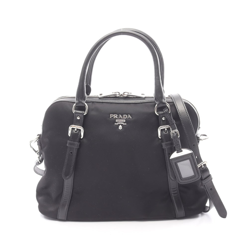 Prada 2 Way Handbag Black: 2 way handbag in black nylon and leather. Includes shoulder strap and name tag. Size 34 x 25 x 15 cm.