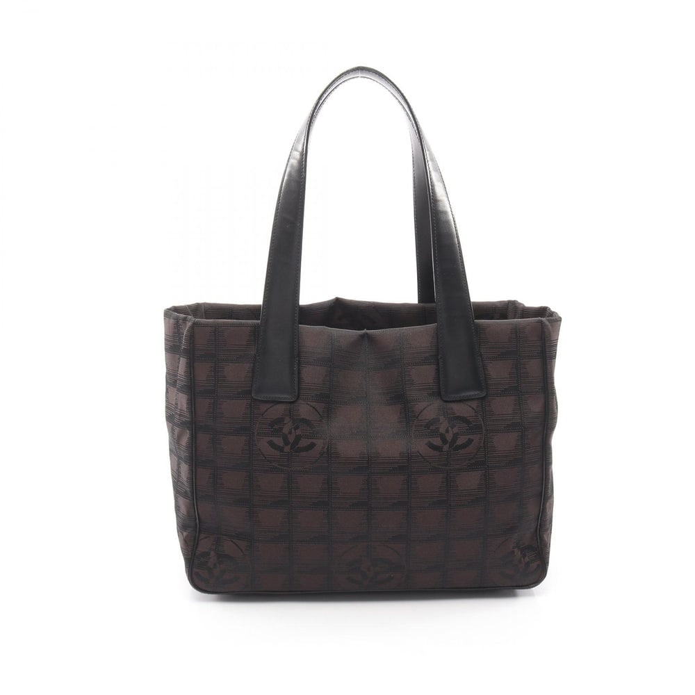 Chanel New Travel Line PM Brown Black: New Travel Line PM tote in dark brown and black nylon canvas with silver-tone hardware. Serial seal included. Size 29 x 21 x 12 cm.