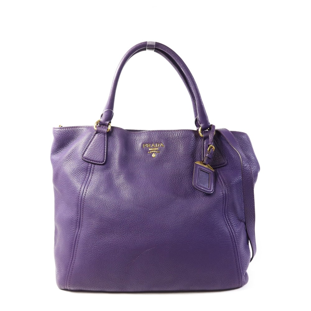 Prada Purple Calfskin 2 Way Bag: Authentic and authenticated Prada 2 way shoulder bag in purple calfskin. Approx. 35.5W x 33H x 13.5D cm with 44 cm handle and 82-92 cm strap. Includes guarantee, shoulder strap, and name tag.