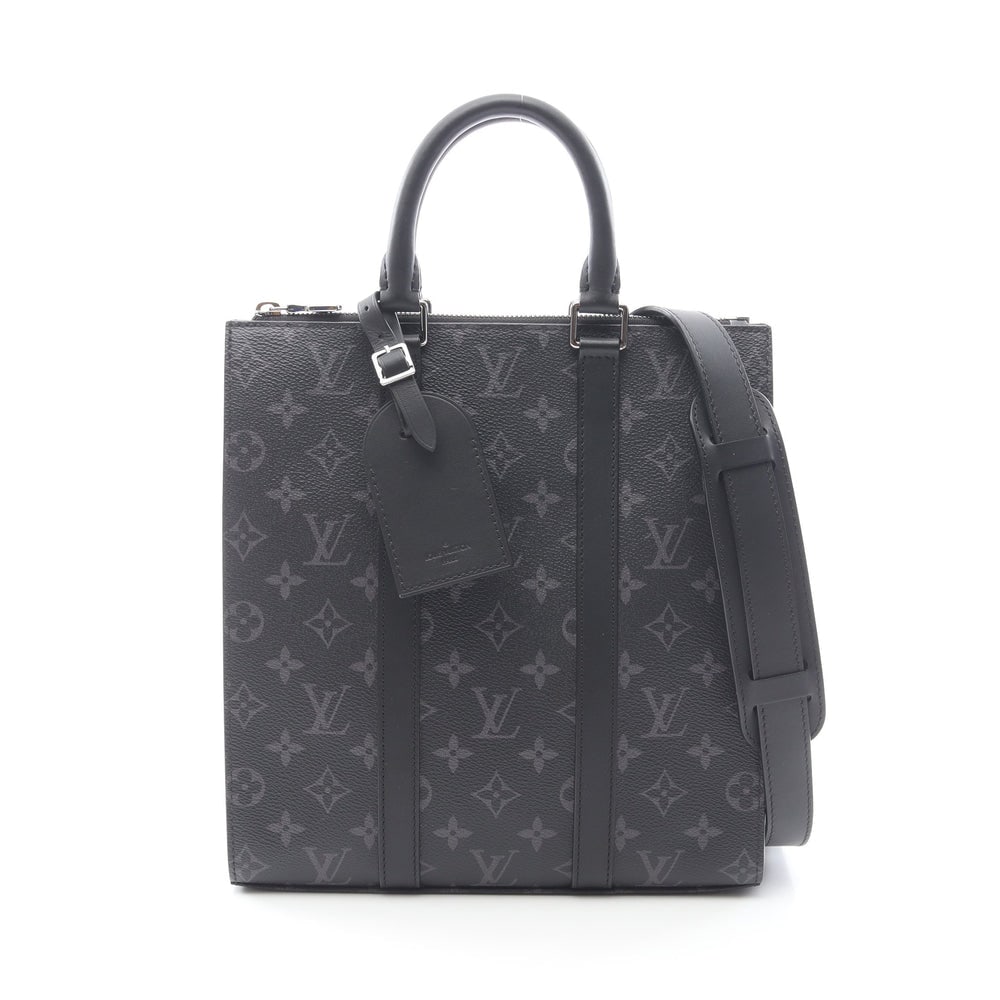 LV Sac Plat Cloth Eclipse Black: Black Monogram Eclipse PVC leather Sac Plat Cloth 2-way handbag with shoulder strap and charm. Approx. 26 x 28 x 6.5 cm; handle 29 cm; strap 89-113 cm. Model M46456, RFID. Authentic and authenticated.