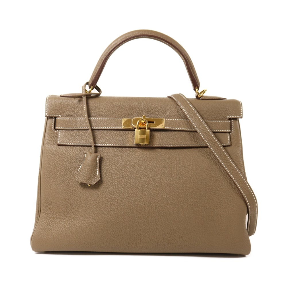 Hermes Kelly 32 Etoupe: Etoupe togo leather 2Way shoulder bag with gold hardware. Includes storage bag strap key and cadena. 32 x 23 x 12 cm.