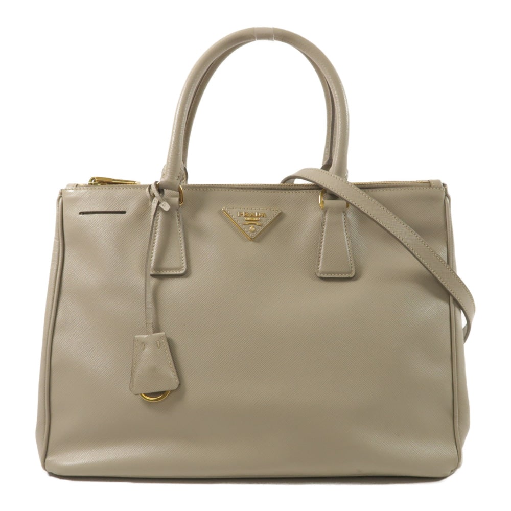 Prada 2 Way Shoulder Gray: 2 way shoulder bag in gray calfskin with gold-tone hardware. Includes storage bags, shoulder strap, and clochette. Size 34 x 24 x 15 cm.