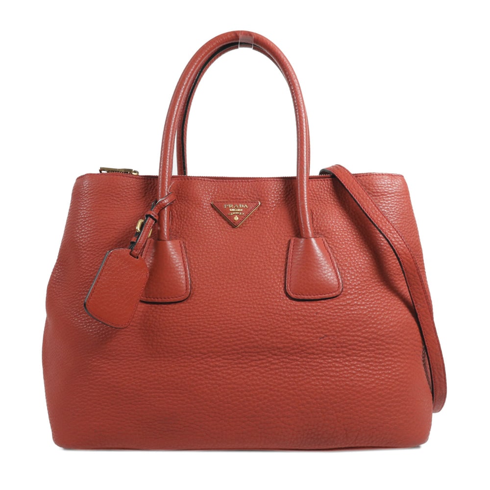Prada Red Calfskin 2 Way Bag: Authentic and authenticated Prada 2 way shoulder handbag in red calfskin. Approx. 36W x 27H x 17D cm with 38 cm handle and 110-120 cm strap. Includes shoulder strap.