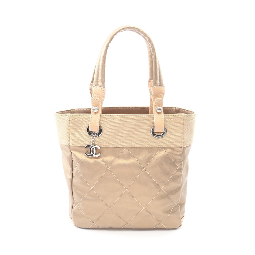 Chanel Paris Biarritz PM Tote: Authentic and authenticated Chanel Paris Biarritz PM handbag tote in champagne gold beige coated canvas and leather with silver hardware. Model A34208. Includes guarantee card and serial seal.