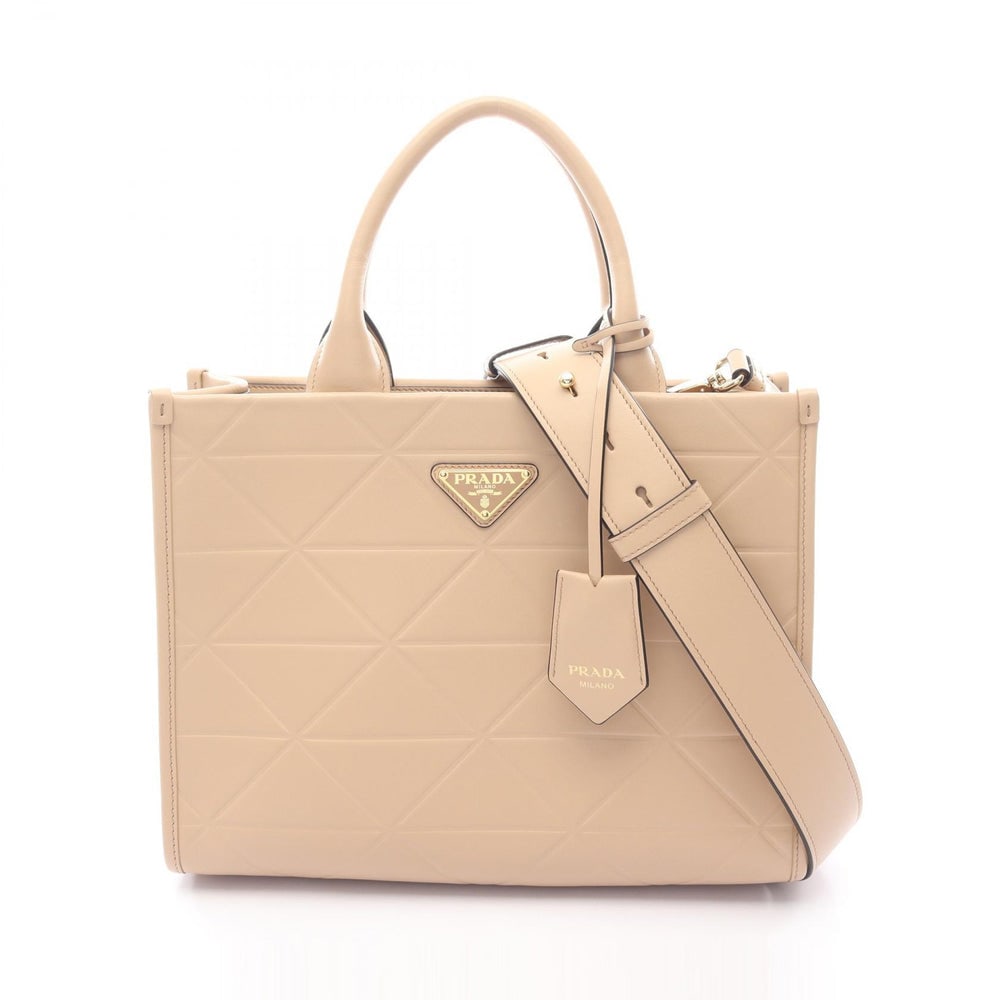 Prada Symbol Topstitching Beige: Beige leather Prada Symbol Topstitching SOFT CALF tote handbag. Approx. 30 x 23 x 10.5 cm; handle 33.5 cm; strap 103-115 cm. Model 1BA379. Authentic and authenticated.
