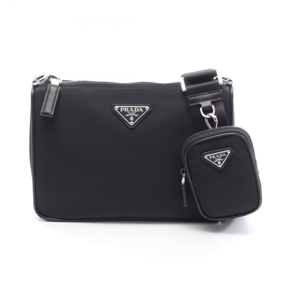 Prada Saffiano Travel Black: Black nylon and leather Prada SAFFIANO TRAVEL shoulder bag. Approx. 23.5 x 16.5 x 5.5 cm; strap 97-142 cm. Authentic and authenticated.