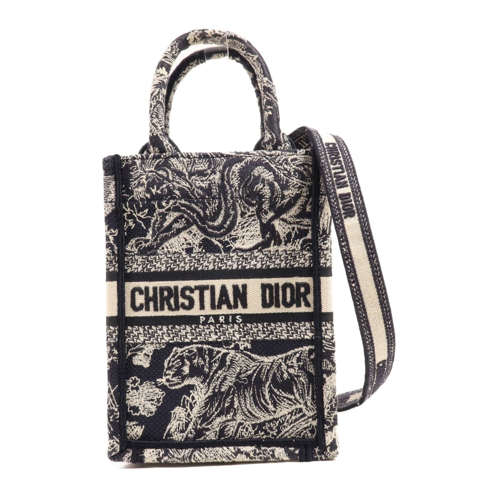 Dior Book Tote Mini Navy Beige: Navy and beige canvas Dior Book Tote Mini 2-way bag. Approx. 13 x 18 x 8 cm; handle 20 cm; strap 67-121 cm. Product no. 50-MA-1202. Authentic and authenticated.