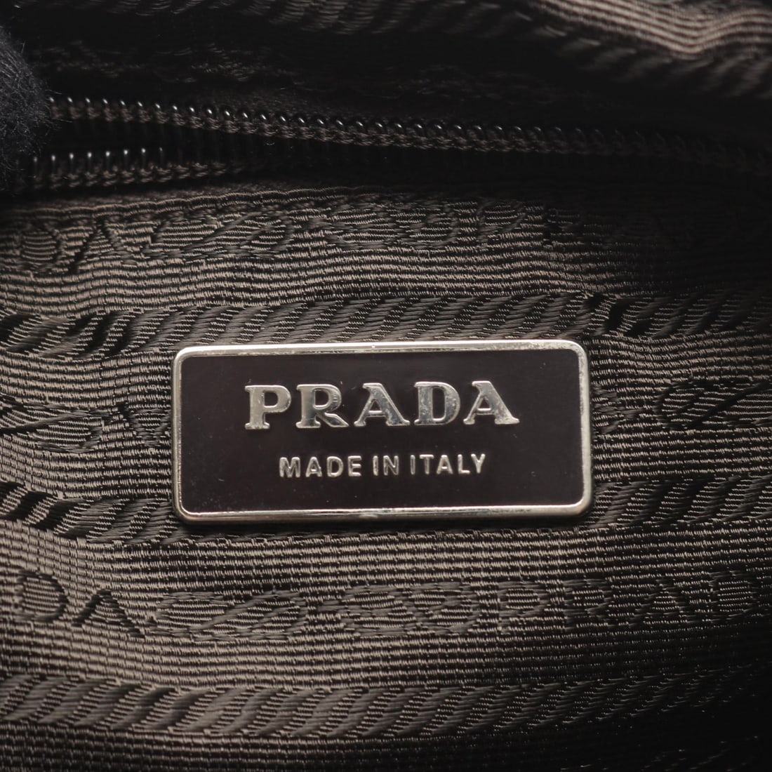 Prada Drawstring Nylon Backpack Brown: Authentic and authenticated Prada logo plate drawstring backpack in khaki brown nylon and leather. Approx. 33H x 29W x 14.5D cm with 73-76 cm straps. No accessories listed.