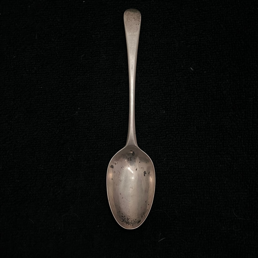Old English Sterling Silver Spoon 32.1 g: Single hallmarked spoon with a plain tapered Old English–style handle and oval bowl. Reverse handle shows multiple punched marks. Approximate length is 6.5 inches, with photographed weight of 32.1