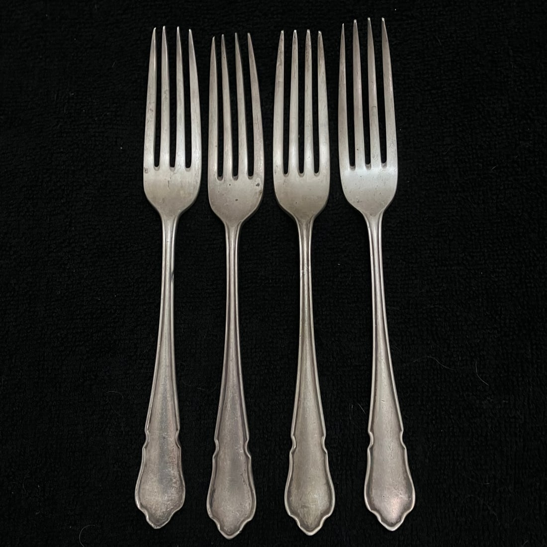 B&H Hallmarked Sterling Silver Forks 300.0 g: Set of four matching hallmarked silver flatware forks with four tines and plain shaped handles. Each piece bears a B&H mark along with additional British-style assay hallmarks. Approximate length is
