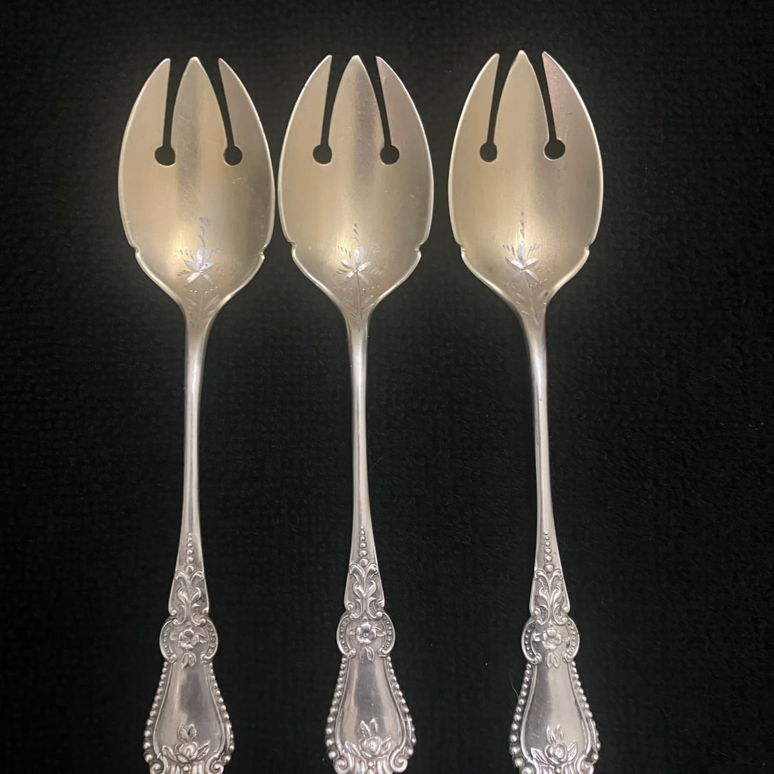 Sterling Silver Pierced Fruit Forks Set 42.3 g: Set of three matching sterling silver specialty flatware pieces with pierced three-point heads, ornate floral handles, and engraved floral decoration on the bowls. Reverse stamped "STERLING 925" and "