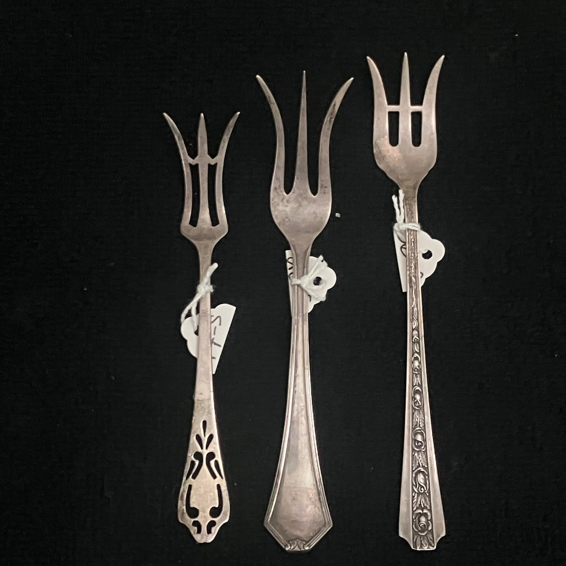 3 Small Sterling Silver Forks 36.6 g: Group of three assorted small sterling silver specialty forks in mixed patterns. The lot includes one pierced-handle fork, one plain tapered-handle three-point fork, and one decorated floral-handle