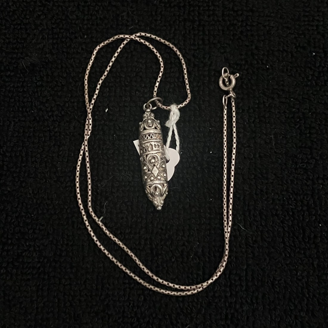 18" Sterling Silver Pendant Necklace 7.3 g: Sterling-marked pendant necklace with a fine link chain and an elongated ornate capsule-form pendant. Spring-ring clasp is stamped 925, and the pendant reverse is stamped STERLING with an additional