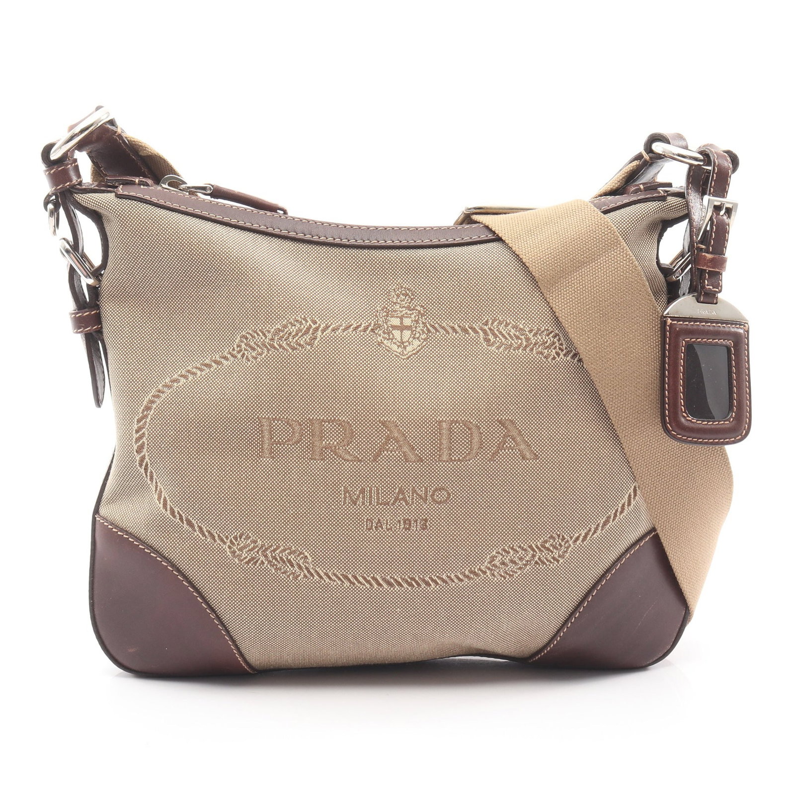Prada Logo Jacquard Hobo Beige Brown: Beige brown LOGO JACQUARD one shoulder bag in canvas and leather. Accessories: name tag. Size: H23 x W25-28 x D2 cm; strap 77-123 cm.