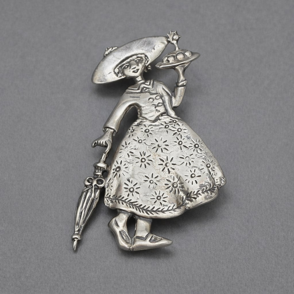 Mary Engelbreit Sterling Lady Umbrella Brooch: Vintage Mary Engelbreit sterling silver figural brooch, signed “ME” and marked 925 on the reverse. Charming Engelbreit-style lady in period dress holding an umbrella and serving tray, with eng
