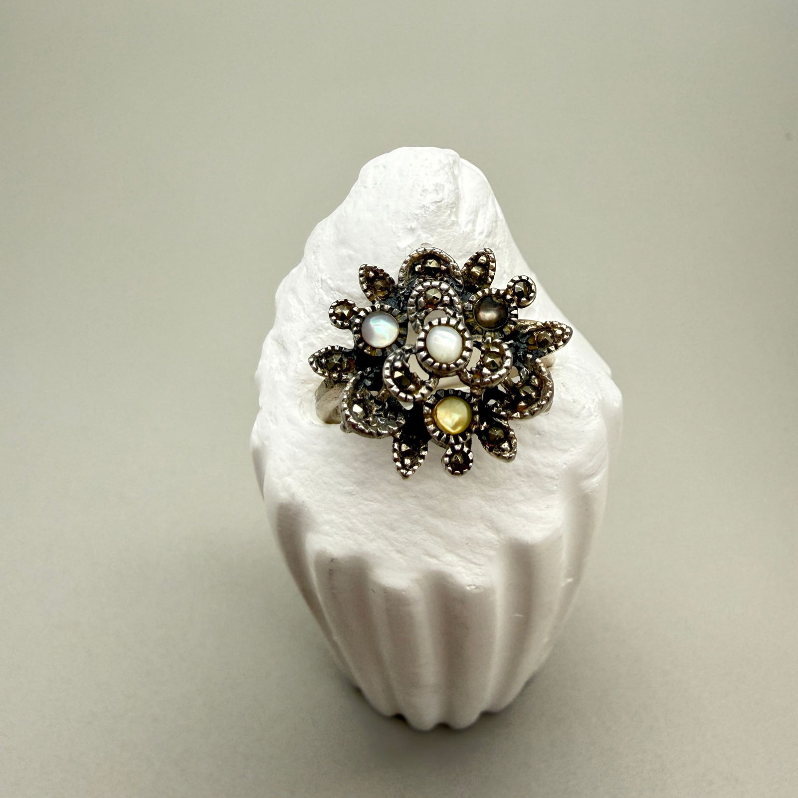 Sterling Marcasite Floral Cluster Ring Mixed Cabochons: Vintage sterling silver floral cluster ring accented with faceted marcasite and multiple small cabochons in varying soft tones (white, yellow, gray, and blush). Stones are untested and described by ap