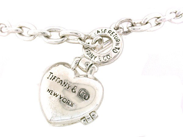 Tiffany Heart Locket and Necklace: This is a PRE-OWNED Tiffany Heart Locket and Necklace. It is stamped with Please Return to Tiffany & Co at the base of the necklace and Tiffany & Co New York on the locket.