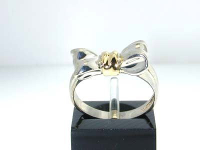 Tiffany & Co. Silver and 18K Yellow Gold Ring: The weight of this ring is 3.6 g. The size of the ring is 6.5. The size of the surface (the bow) is 15 x 5 mm.