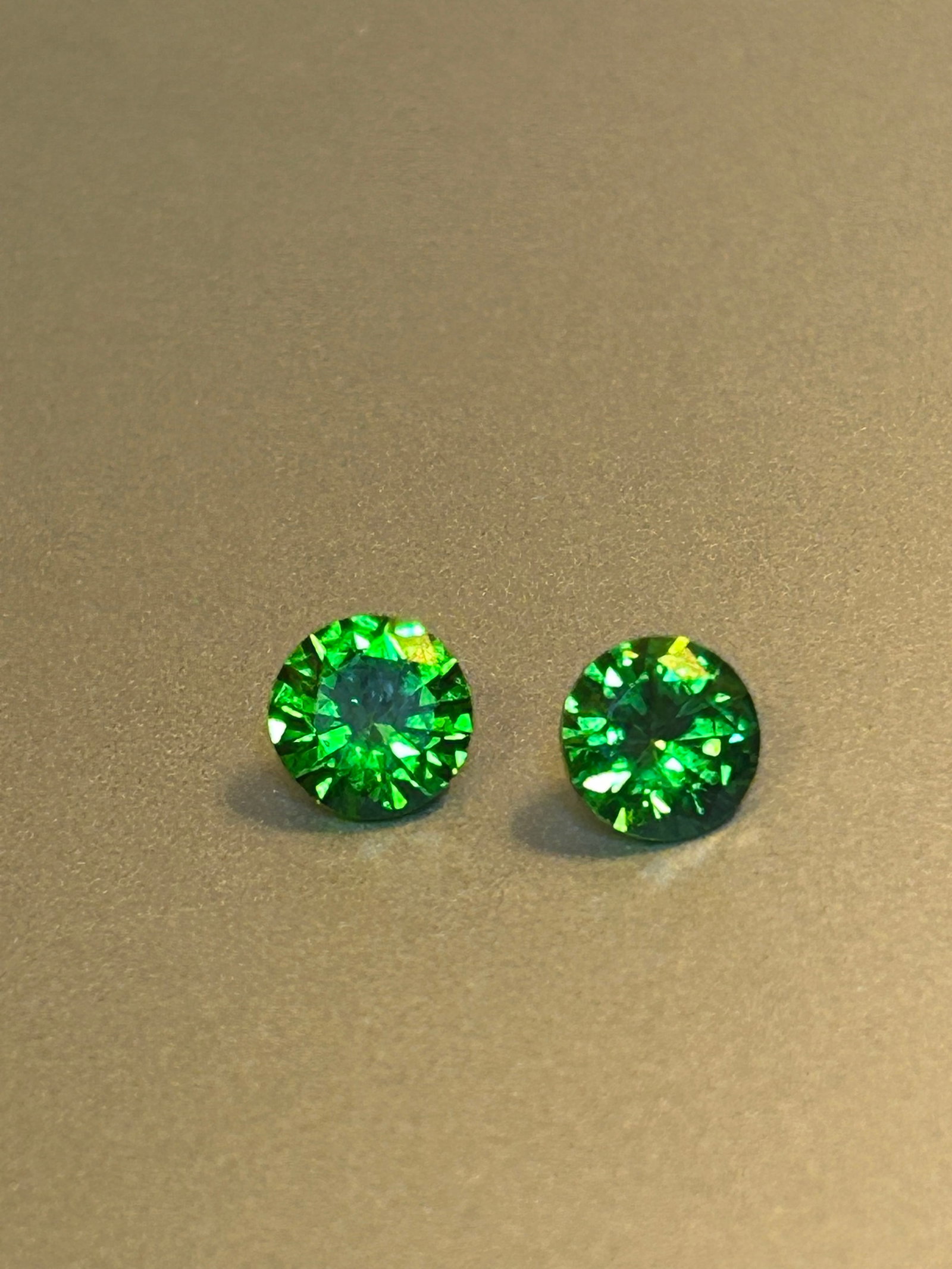 Green Emerald Round Cut 3.70 Ct Pair from Colombia: 9 x 9 x 5mm a vibrant, rich green color and generally good, eye-visible, or slightly included (SI) clarity, characteristic of fine Colombian gem.