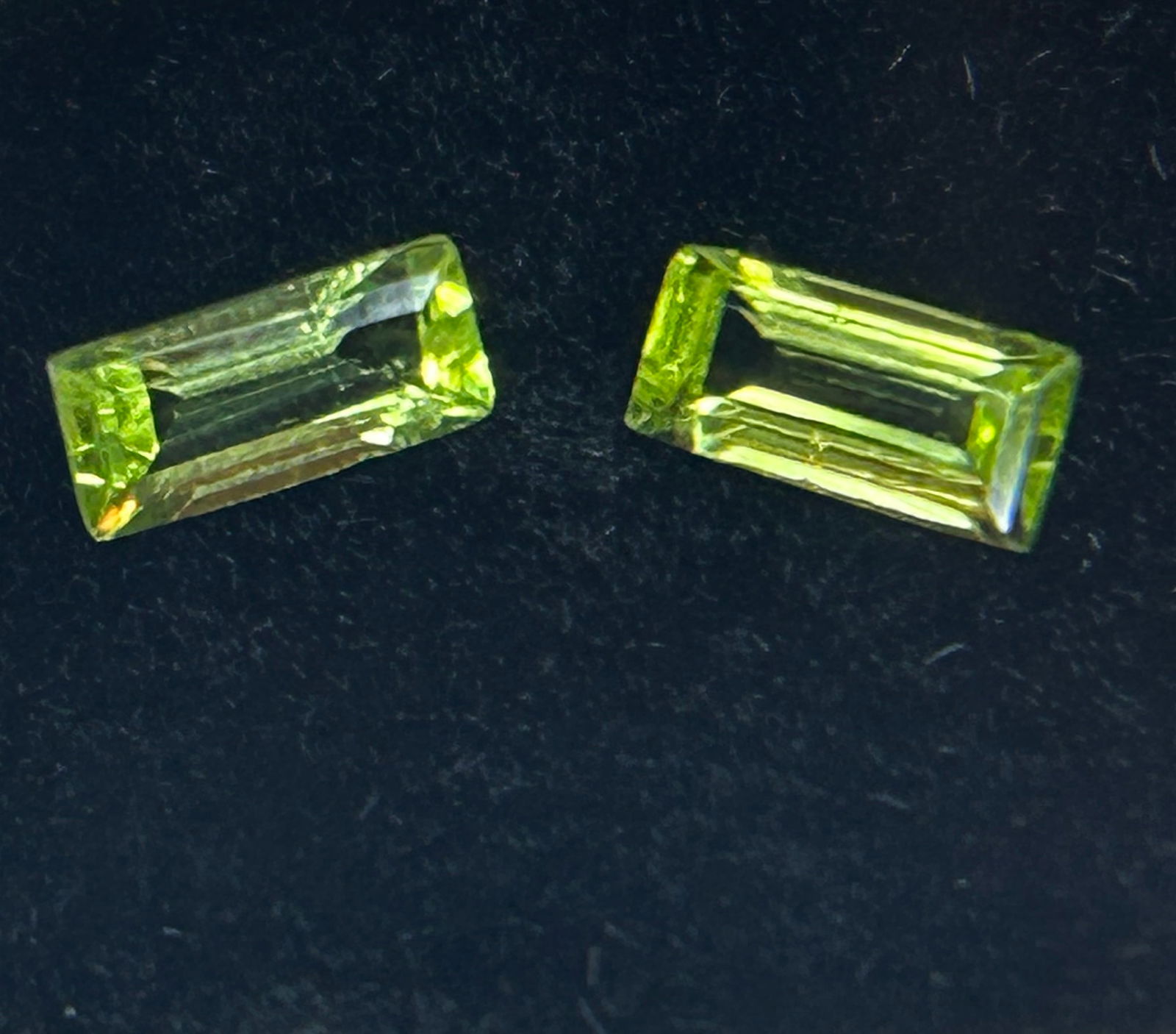 8ct Natural Pigeon Blood Ruby Oval Cut from Burma: A 1.67-carat total weight pair of rectangular, faceted natural peridot gemstones featuring a vibrant green color. These stones are sourced from Arizona